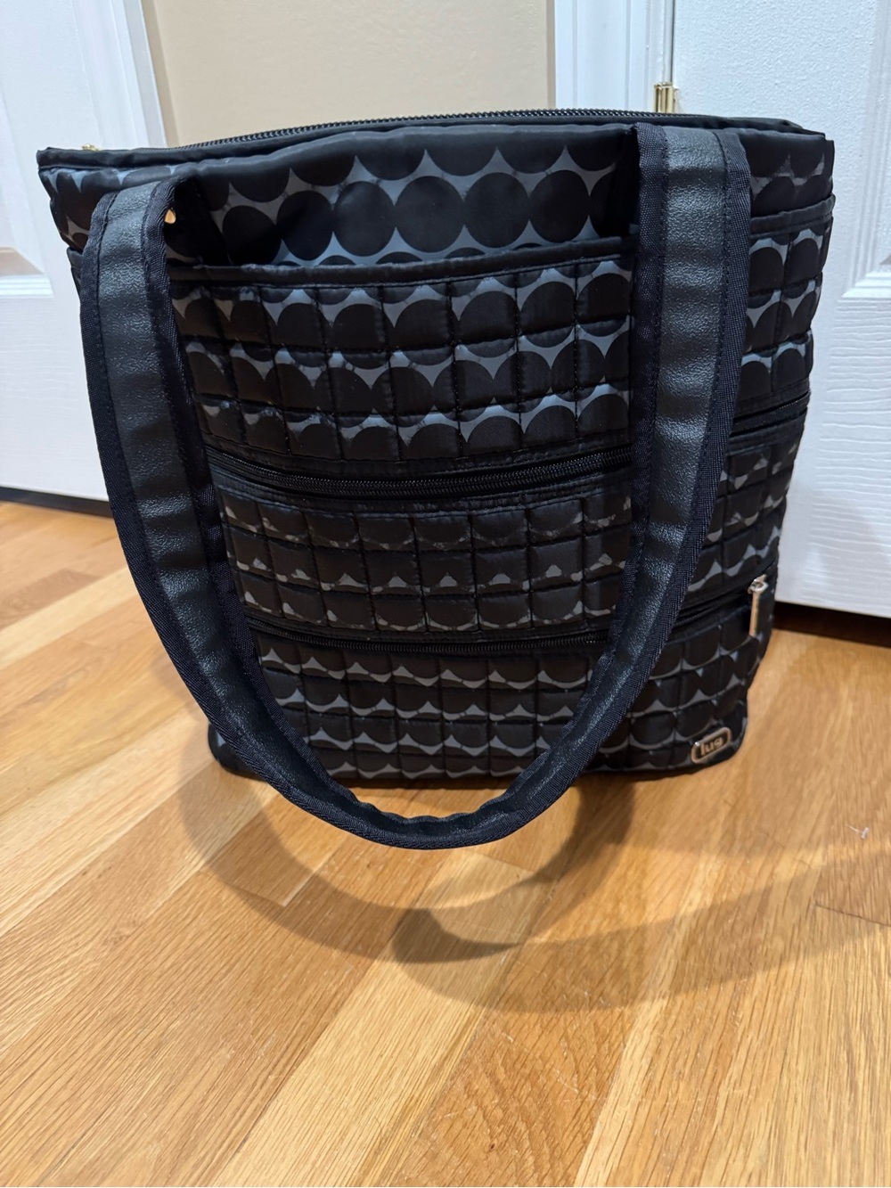 Black lug quilted Taxi Tote. Shoulder straps and luggage slide. NWOT